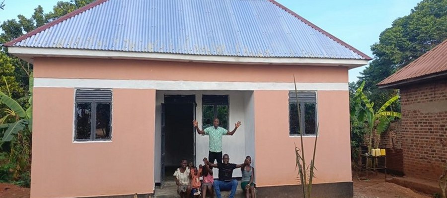 Mary Auma and her children on the step of the new house