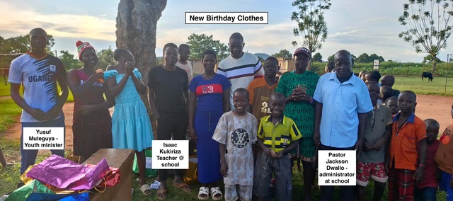 Children in their new birthday clothes with school staff