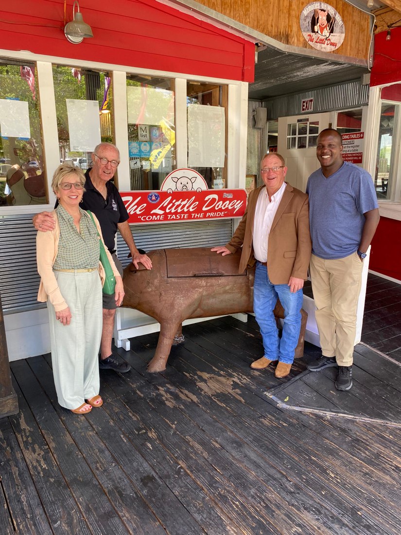Enock Nkulanga with Max and Vicki Alston on the porch of The Little Dooey