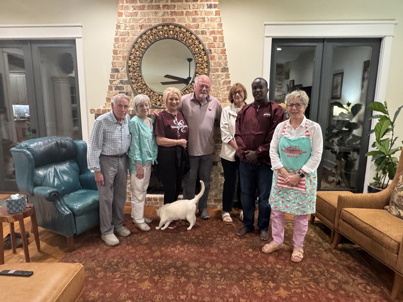 Enock standing with a group of friends in a living room