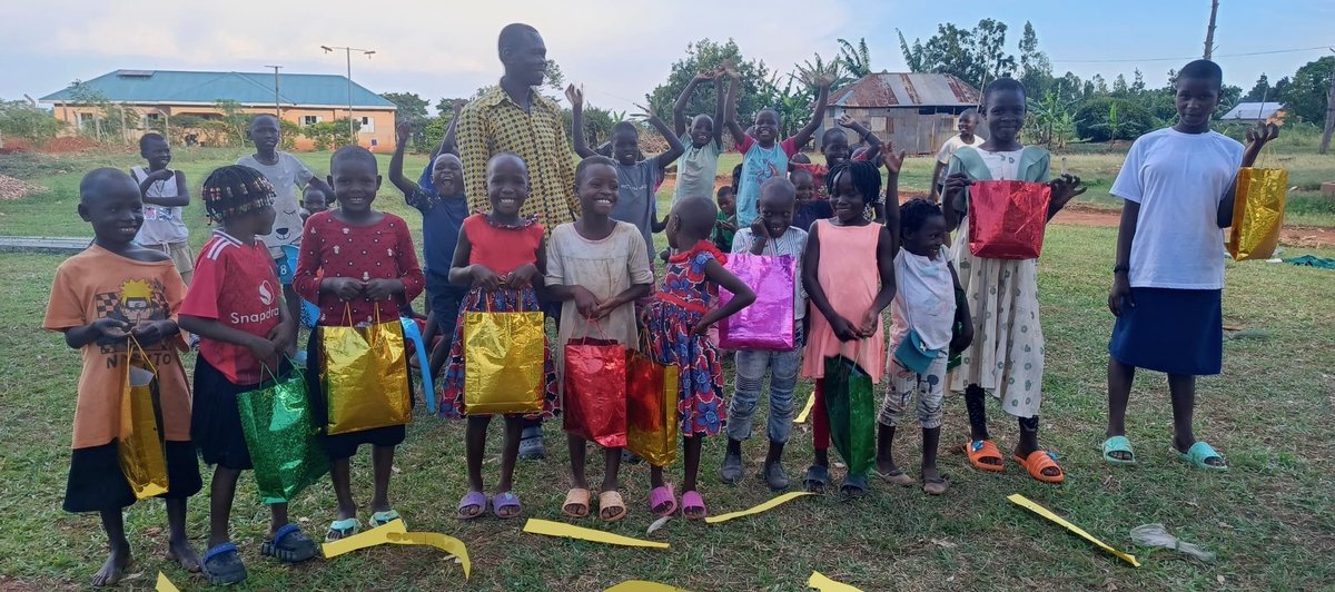 Children at Great Love Junior Academy holding their birthday gift bags on party day